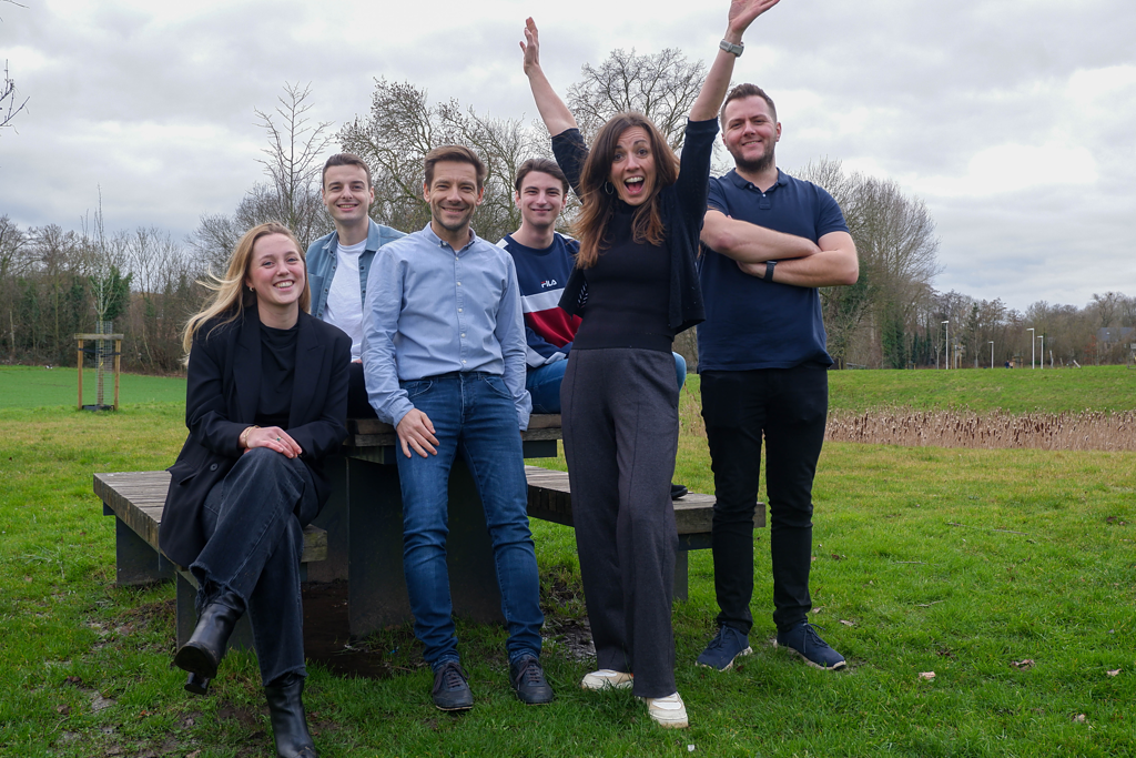 Het team van Assistu aan een bankje