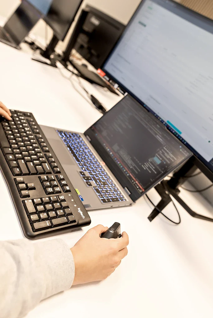 Handen op het toetsenbord met code op het scherm