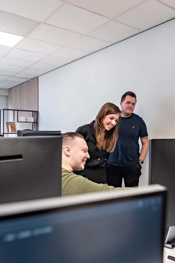 Drie collega's overleggen aan een scherm
