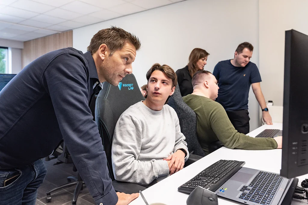 Het Assistu-team kijkt samen mee op een scherm