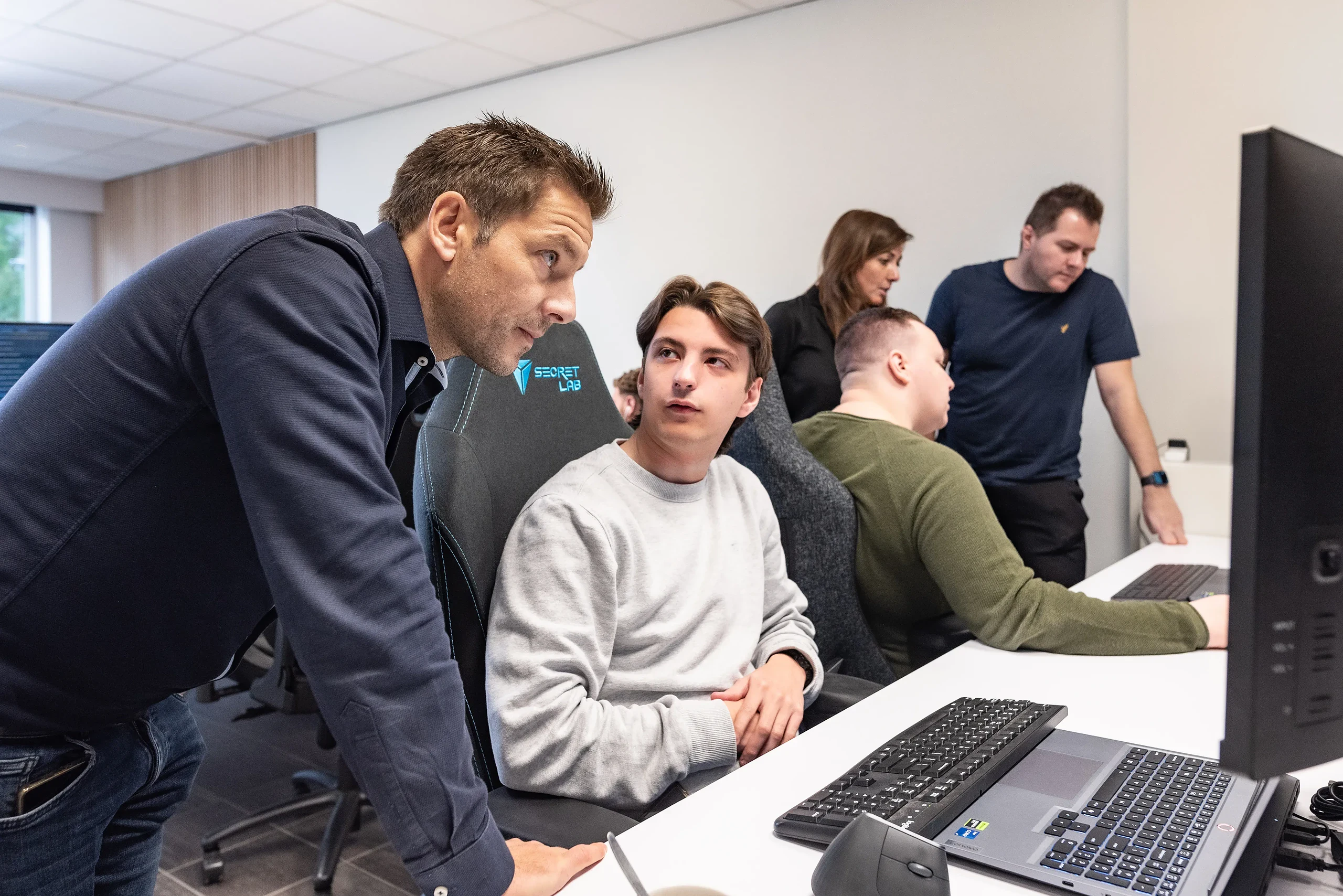 Collega's kijken samen mee op een scherm tijdens een werksessie